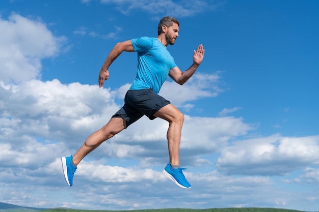 Sportif en bonne santé avec un corps musclé en cours d'exécution dans des vêtements de sport en plein air sur le sport de fond de ciel