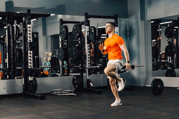 Un sportif courant sur place et faisant des exercices d'échauffement dans une salle de sport