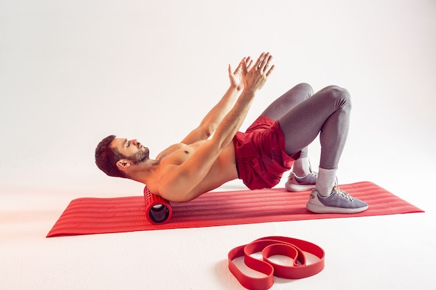 Le sportif entraîne les muscles abdominaux sur un tapis de fitness