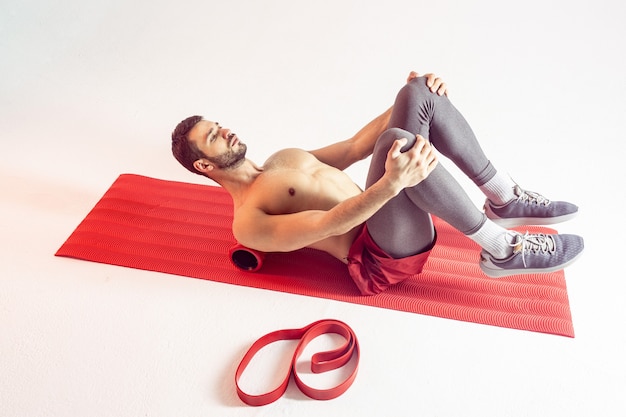 Le sportif entraîne les muscles abdominaux sur un tapis de fitness
