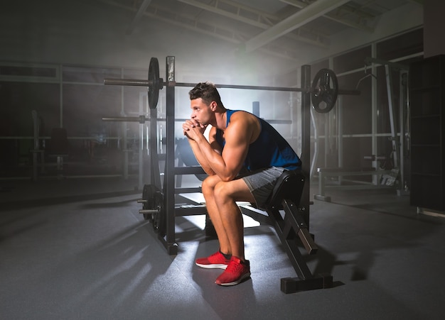 Le sportif fatigué s'asseoir dans le centre sportif