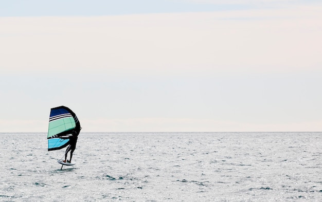 sportif avec feuille d'aile naviguant dans la mer