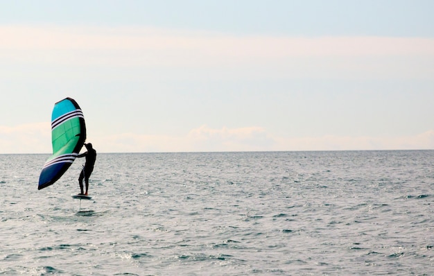 sportif avec feuille d'aile naviguant dans la mer