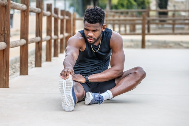 Un sportif fort faisant un exercice d'atteinte des orteils sur le sol