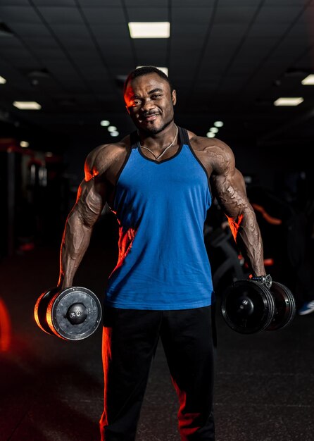 homme de sport africain musclé fort faisant de l'exercice en poids avec  haltère dans la salle de fitness de la salle de sport. musculation sport  homme fitness concept. 11875734 Photo de stock