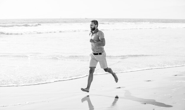 Sportif mature faisant du jogging sur la plage pendant les vacances d'été pour le sport d'entraînement