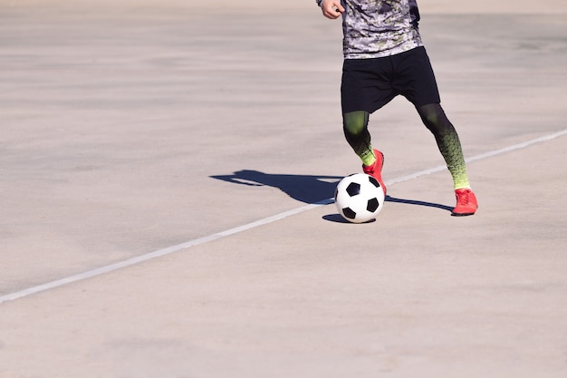 Sportif méconnaissable jouant avec le ballon