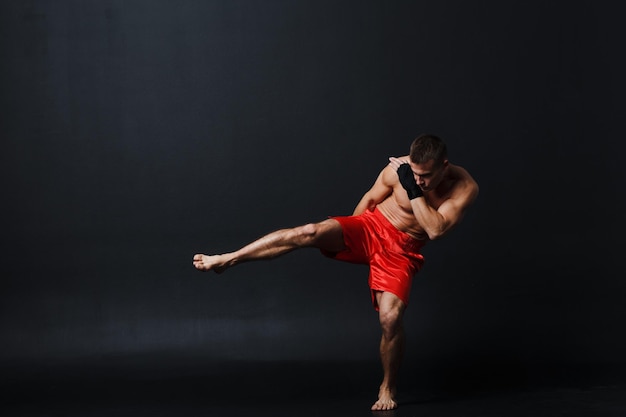 Sportif muay thai homme boxeur position sur fond noir