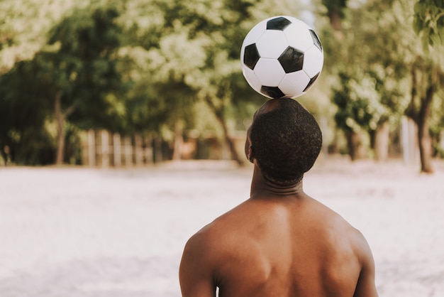 Sportif, plage, tient, balle football, sur, tête