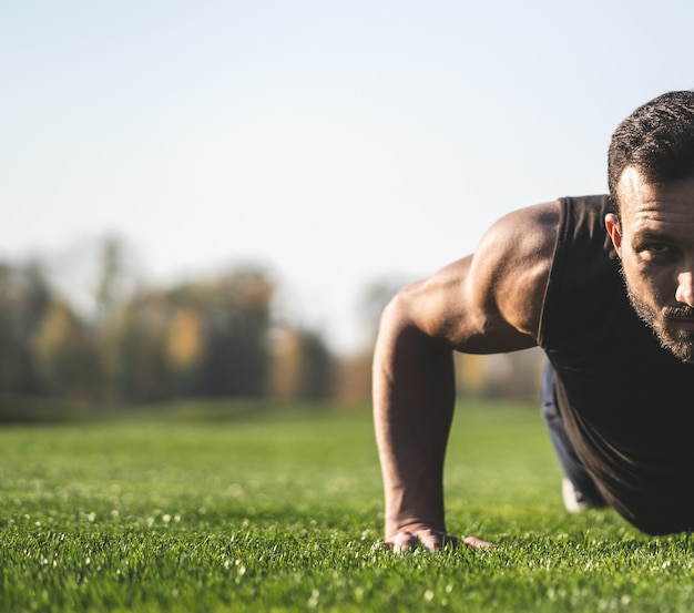 Le sportif poussant sur l'herbe