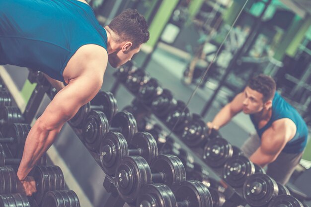 Le sportif prend un haltère dans la salle de gym