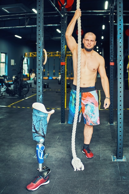 Sportif avec prothèse s'entrainant dans une salle de sport