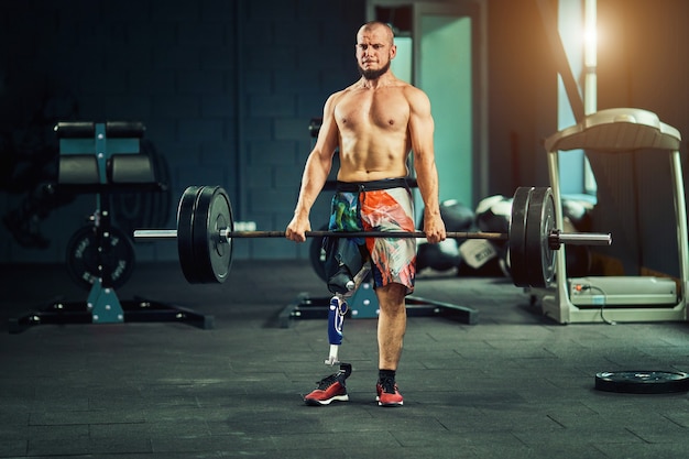Sportif avec prothèse s'entrainant dans une salle de sport