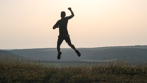 Le sportif saute au sommet de la montagne