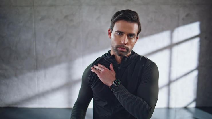 Photo sportif sérieux réchauffant l'épaule au studio portrait homme de fitness exercices