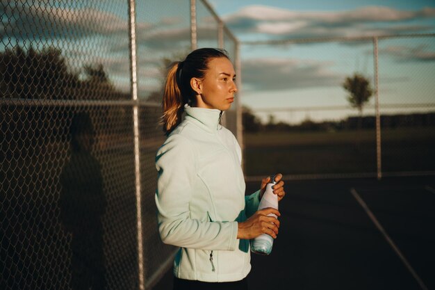 La sportive boit de l'eau. La femme maintient l'équilibre hydrique. Sports de plein air. Photographie de portrait.