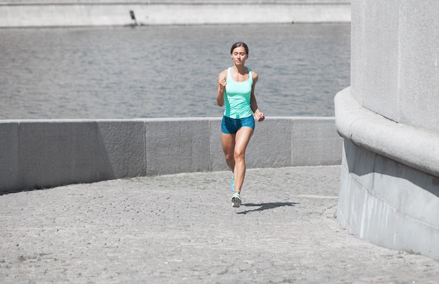 Photo sportive caucasienne jogging en montée sur la route de pierre