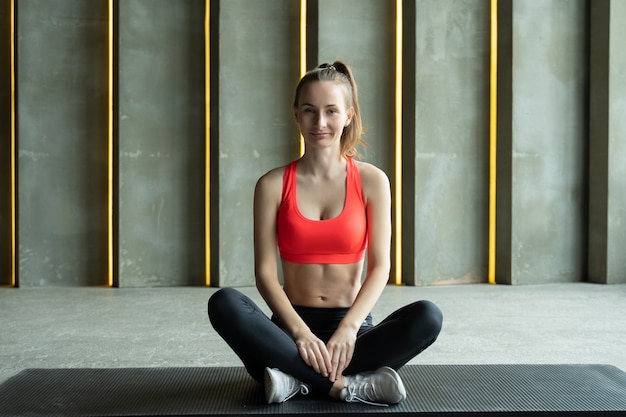 Sportive est assise sur un tapis