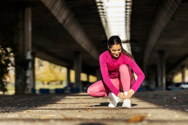 Une sportive en forme attache ses lacets.