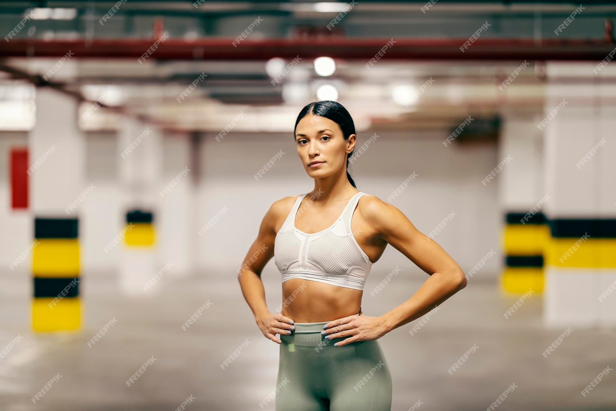 La Sportive Fait Des Exercices De Force Pour Les Biceps Tout En étant  Assise Dans Un Garage Souterrain