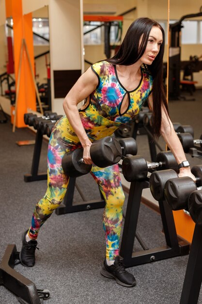 Sportive avec des haltères dans la salle de gym