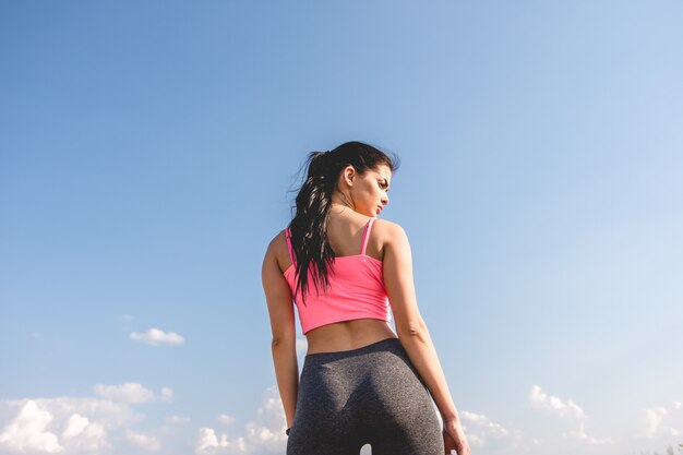 La sportive se tient derrière sur le fond des nuages