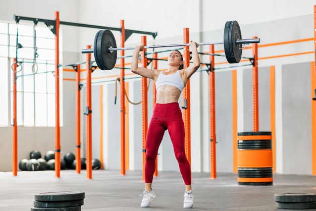 Sportive tendue faisant pousser la barre d'haltères