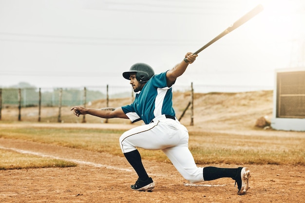 Sports de baseball et coup de circuit avec un homme athlète ou frappeur frappant et marquant lors d'un match en plein air sur un terrain Fitness sportif et exercice avec un joueur masculin sur un terrain pour l'entraînement ou un match