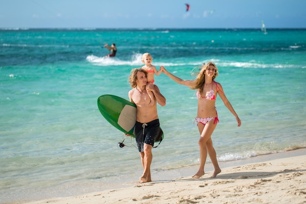 Sports famille papa, maman et fille marchant sur la plage