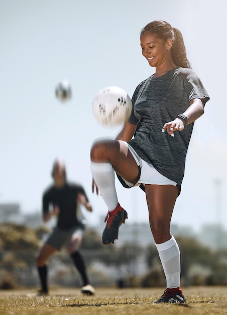 Photo sports de football et entraînement avec une femme jonglant avec les genoux pour des exercices d'entraînement et de remise en forme sur le terrain bien-être et pratique avec un athlète et un ballon de football pour des objectifs de jeu ou un mode de vie cardio