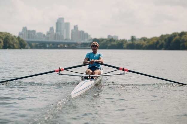 Sportsman seul homme rameur aviron sur bateau.