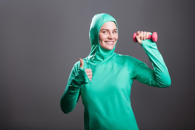 Sportwoman en sportwear vert sur fond gris