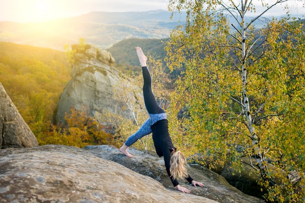 Sporty fit femme pratique le yoga au sommet de la montagne