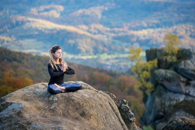 Sporty fit femme pratique le yoga au sommet de la montagne