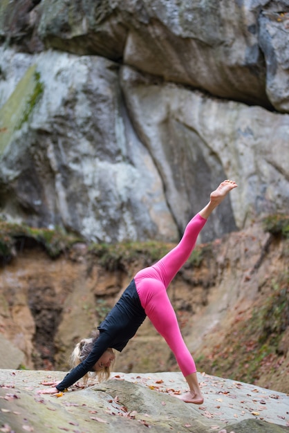 Sporty fit femme pratique le yoga sur le rocher dans la nature