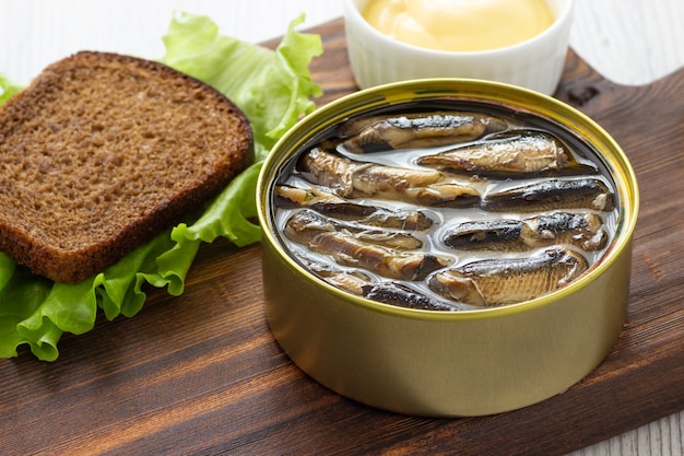 Sprats en conserve en boîte de conserve avec du pain pour sandwich