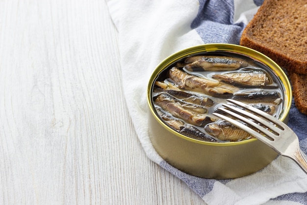 Sprats en conserve en boîte de conserve avec du pain pour sandwich