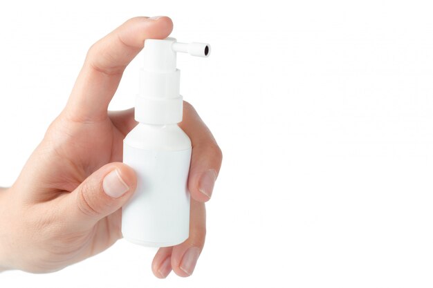 Spray nasal dans une main humaine isolée sur fond blanc