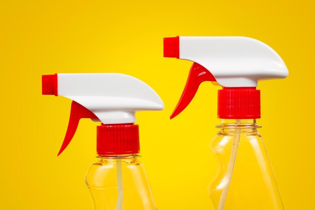 Sprayers de détergent en gros plan sur un fond jaune