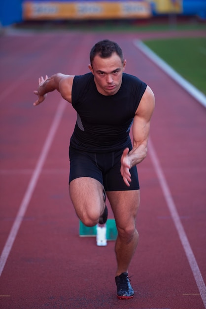 Sprinter laissant les blocs de départ sur la piste de course. Début explosif.