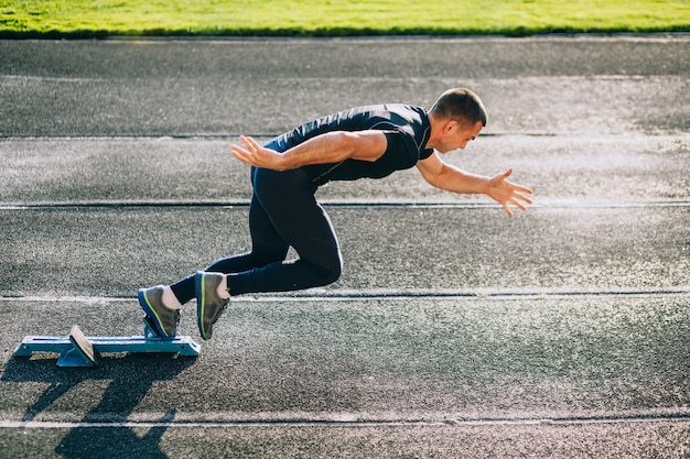 Sprinter laissant des starting-blocks sur la piste de course