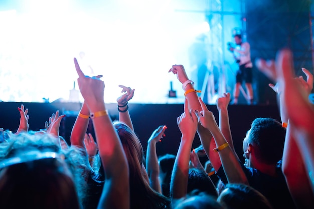 Srowd avec les mains levées au festival de musique Fans profitant d'un concert de rock avec des applaudissements de spectacle de lumière