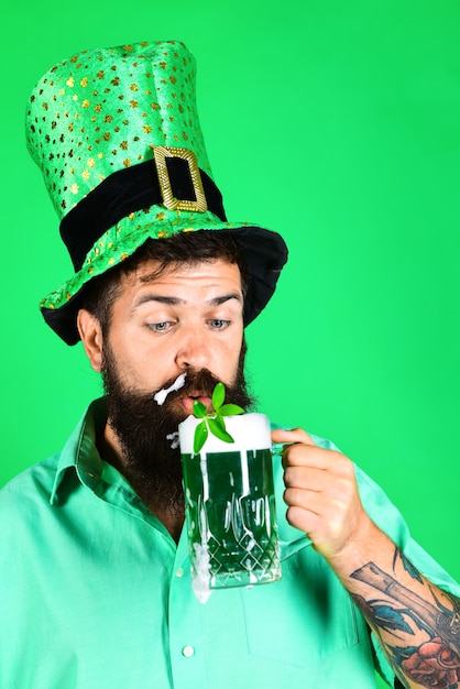 St Patricks day homme barbu en chapeau de lutin portrait d'homme qui boit de la bière verte trèfle dans la bière