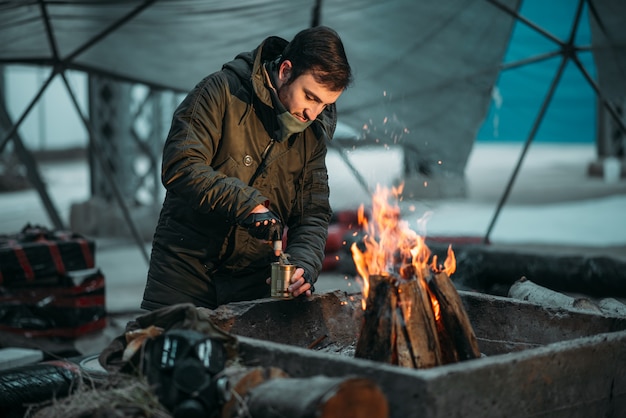 Stalker, personne de sexe masculin la cuisson des aliments en conserve sur le feu