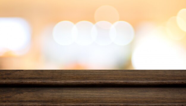 Stand de nourriture de table en bois foncé étape vide avec flou fond abstrait orange lumière bokeh