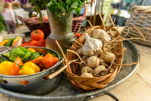 Photo un stand de vente très rustique avec des tomates, des pommes, des poivrons et des fleurs.