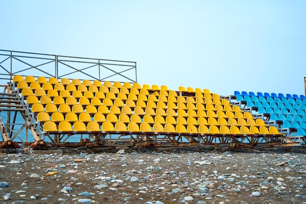 Stands déserts d'un petit terrain de sport sur la plage un jour de pluie.