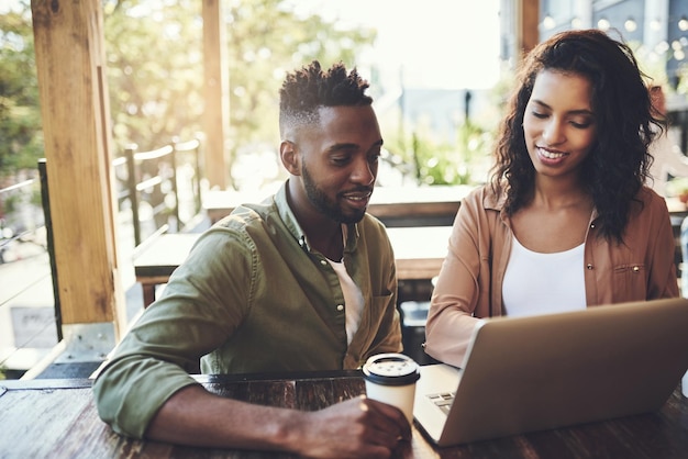 Startup freelance et ordinateur portable au café pour la réunion d'équipe, la recherche ou le développement au restaurant Discussion technologique ou partenaires sur Internet pour la communication en réseau ou la planification au café