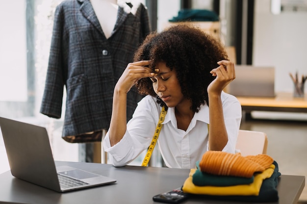 Startup PME petite entreprise entrepreneur d'une femme asiatique indépendante portant un tablier à l'aide d'un ordinateur portable et d'une boîte pour recevoir et examiner les commandes en ligne pour se préparer à emballer la vente aux clients en ligne des idées d'affaires de PME