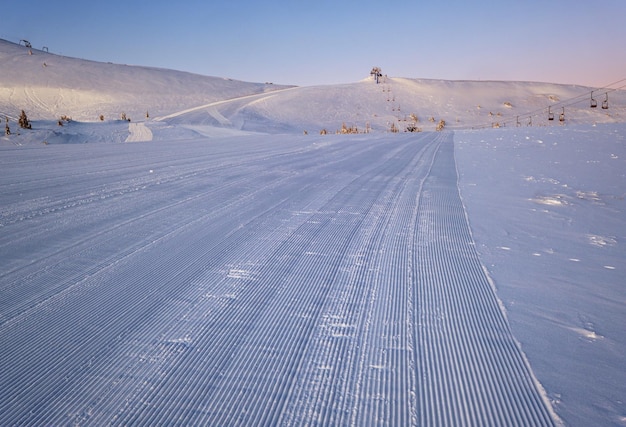 Photo station alpine pistes de ski préparées et remontées mécaniques avant le lever du soleil matin vue sur la crête de montagne dragobrat ukraine carpates